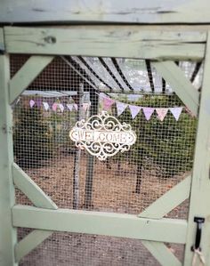 a gate with a sign that says welcome on it and bunting in the background