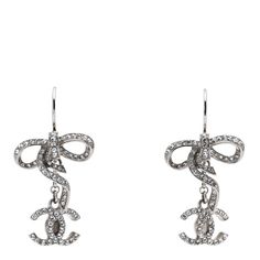 This is an authentic CHANEL Crystal CC Bow Drop Earrings in Silver. These stylish silver tone earrings feature silver bows and a Chanel CC drop pendant, both lined with crystals. Chanel Bow, Drop Earrings Silver, Chanel Earrings, Chanel Accessories, Silver Bow, Chanel Jewelry, Bow Earrings, Silver Drop Earrings, Jewelry Designer