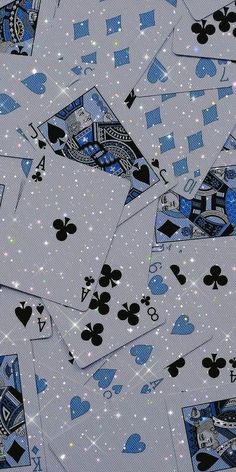 several playing cards are scattered on top of each other in blue and white colors, with sparkles all over them