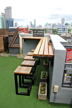 an outdoor dining area on the roof of a building with city skyline in the background