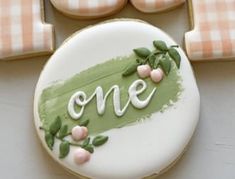 a decorated cookie with the word one on it and some cookies in the shape of letters