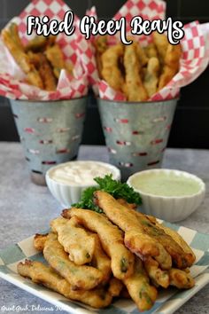 fried green beans on a plate with dipping sauce