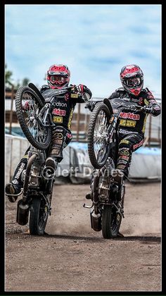 two motorcyclists are performing stunts on their bikes