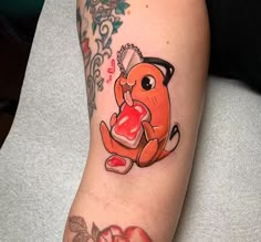 a person with a tattoo on their arm has a red heart in the shape of a dog