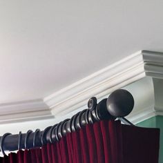 red curtains are hanging from the ceiling in front of a white coffert curtain