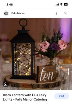 an image of a table setting with flowers in a vase and a lantern on it