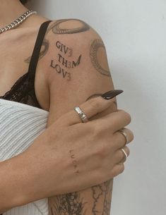 a woman with tattoos on her arm holding onto another person's arm and the words love are written in cursive font