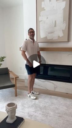 a man is standing in front of a fireplace