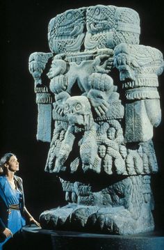 a woman standing in front of a statue