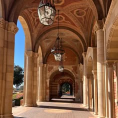 an archway with two lamps hanging from it's sides and another light fixture in the middle