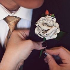 a person tying a boutonniere with musical notes on the lapel cover