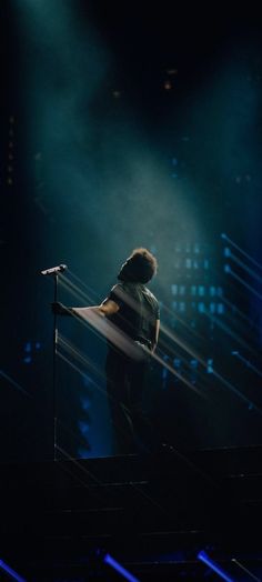 a man standing on top of a stage holding a microphone