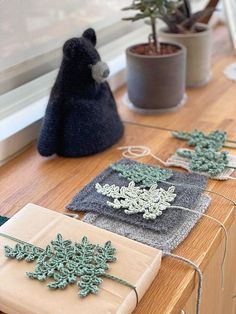 several small knitted snowflakes sitting on a table next to a potted plant