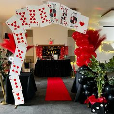 a red carpeted area with black and white decorations, balloons and cards on it