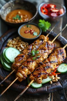 Grilled chicken skewers with dipping sauce, cucumber slices, and peanuts on a wooden platter. Arabian Cuisine, Grilled Kabobs, No Bake Coconut Cookies, Asian Bar, Peanut Butter Curry, Asian Chicken Wraps, Cheesy Broccoli Rice Casserole, Peanut Satay