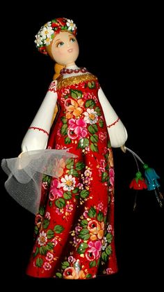 a red and white doll with flowers on it's head