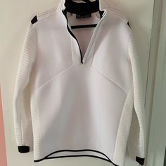 a white and black jacket hanging on a wall