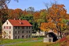 an old stone building surrounded by trees in the fall