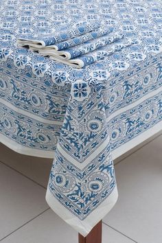 a blue and white table cloth on top of a wooden table