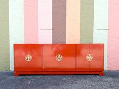 a red cabinet sitting in front of a colorful wall