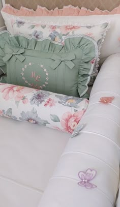 a white couch with pillows on top of it and a pillow in the back ground