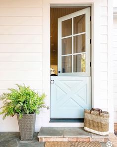 a blue front door with two planters next to it