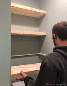 a man is working on some shelves in the bathroom