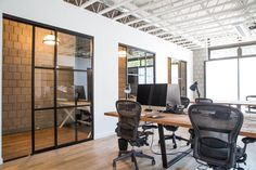 an office with wooden floors and glass doors on the walls is featured in this instagram