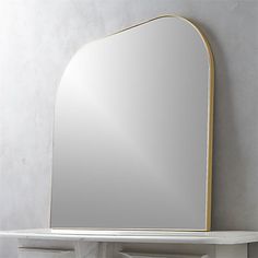 a mirror sitting on top of a white shelf