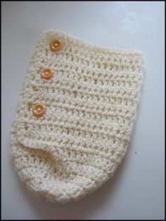 a crocheted baby hat with buttons on it