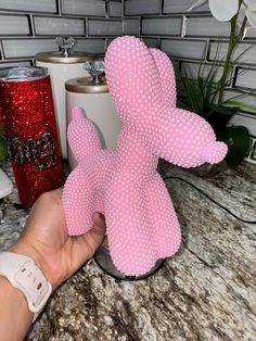 a pink teddy bear sitting on top of a counter