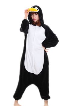 a woman in a black and white animal onesuit is holding a banana up to her head