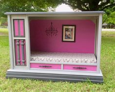 a pink and grey bed in the shape of a doll house with drawers on each side