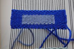 a blue piece of yarn sitting on top of a table next to a weaving machine