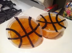 two plastic cups filled with orange juice on top of a counter