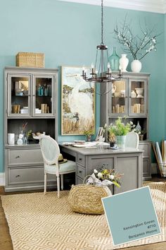 an office with blue walls and furniture in the center, including a chair, desk, bookshelf, and cabinet