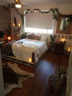 a bed room with a neatly made bed and candles on the floor next to it