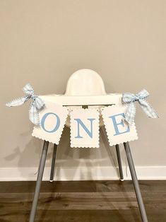 a baby's high chair with a blue and white one sign on the seat