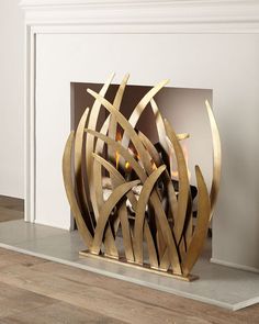 a large metal sculpture sitting on top of a wooden floor next to a fire place