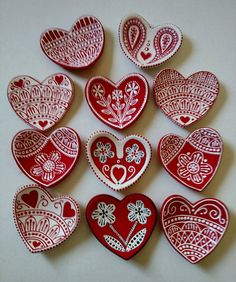 several red and white heart shaped cookies sitting on top of a table