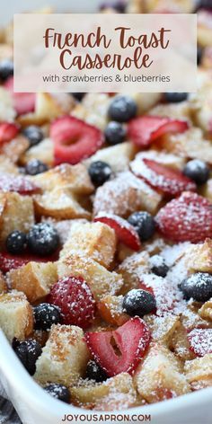 berry french toast casserole with powdered sugar and fresh berries in the baking dish