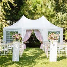 a white tent set up with chairs and flowers