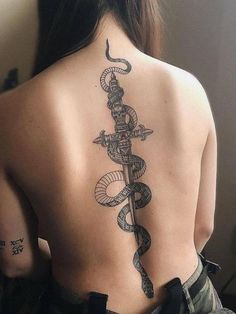 a woman with a snake and dagger tattoo on her back