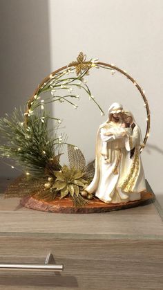 a nativity scene is displayed on a wooden table with greenery and candlesticks