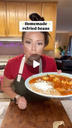 a woman holding a plate of food in front of her face with the caption homemade refried beans