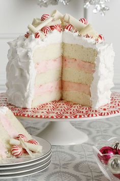 a cake with white frosting and candy canes on the top is cut in half