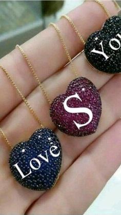 three heart shaped necklaces with the words love and you written on them in different colors