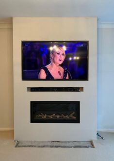 a flat screen tv mounted to the side of a wall next to a fire place