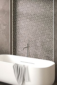 a white bath tub sitting next to a tiled wall