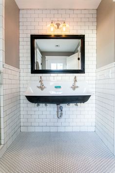 a bathroom with white tile and black sink